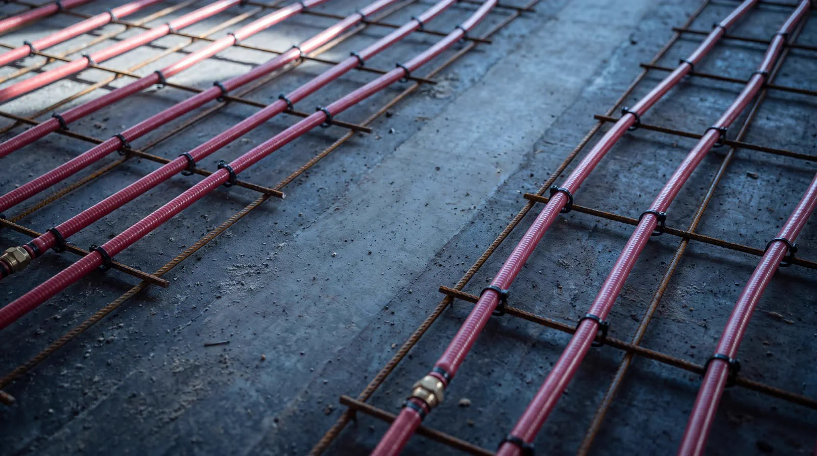Tubes de plancher radiant fixés à un treillis d'armature sur une dalle de béton
